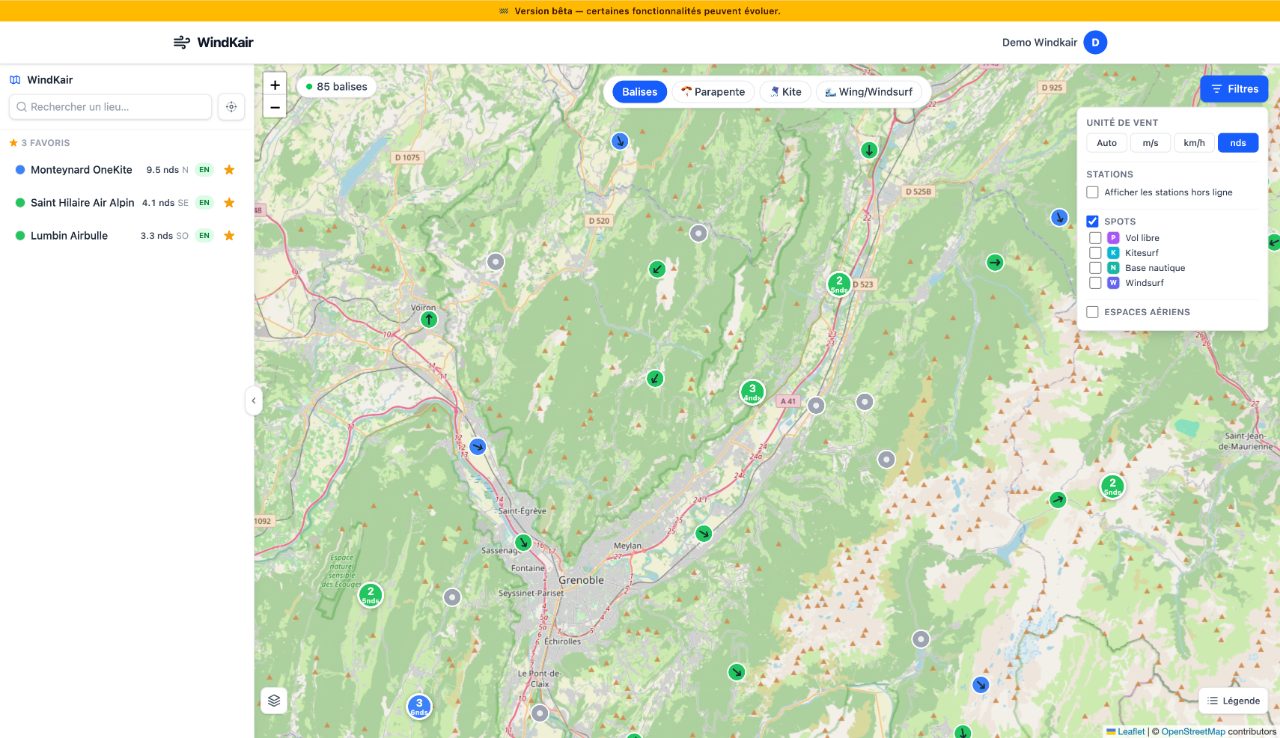 La carte Windkair sur la région de Grenoble : les balises colorées selon la force du vent, chacune fléchée dans la direction d'où il souffle, le panneau des spots favoris à gauche et les filtres ouverts à droite sur l'unité de vent et les types de spots.